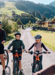 Familie mit Mountainbikes bei einer gemeinsamen Radtour in Großarl