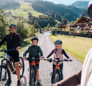 Familie mit Mountainbikes bei einer gemeinsamen Radtour in Großarl