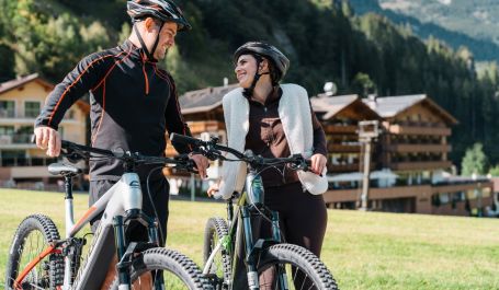 Paar mit E Bikes vor dem Hotel Kristall in Großarl