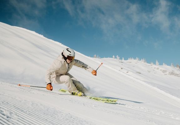 Skifahrer auf einer sonnigen Skipiste im Skigebiet Großarl in Ski amadé